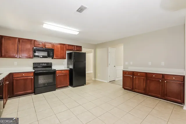 a kitchen with stainless steel appliances granite countertop a refrigerator and a stove top oven