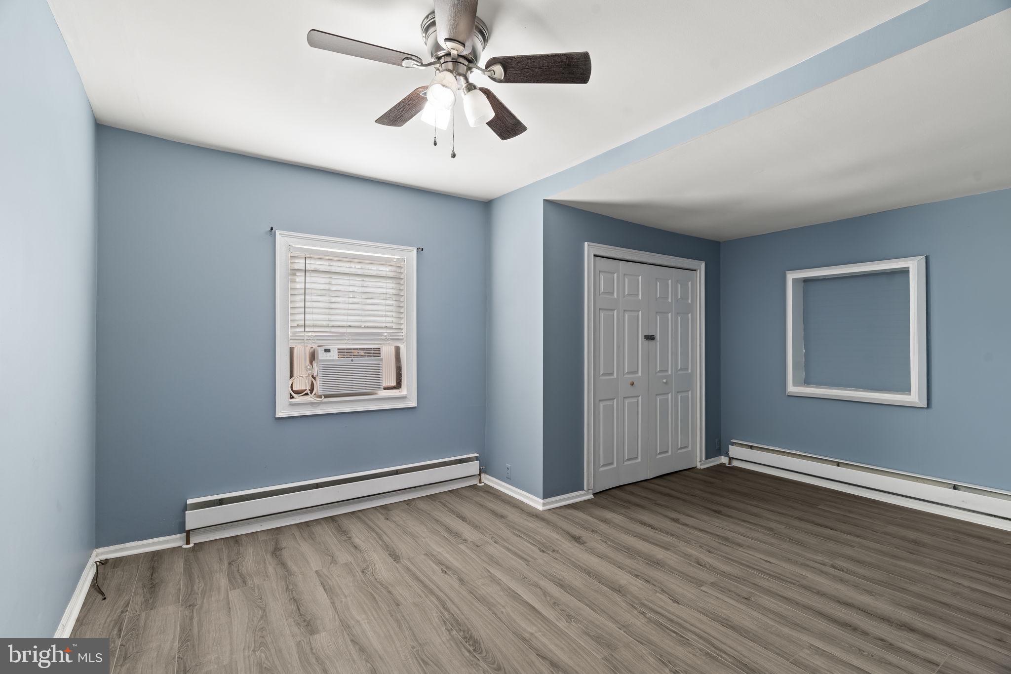 2810 Panther Road Vineland, NJ 08361 - Photo 8 of 20 an empty room with wooden floor chandelier fan and windows