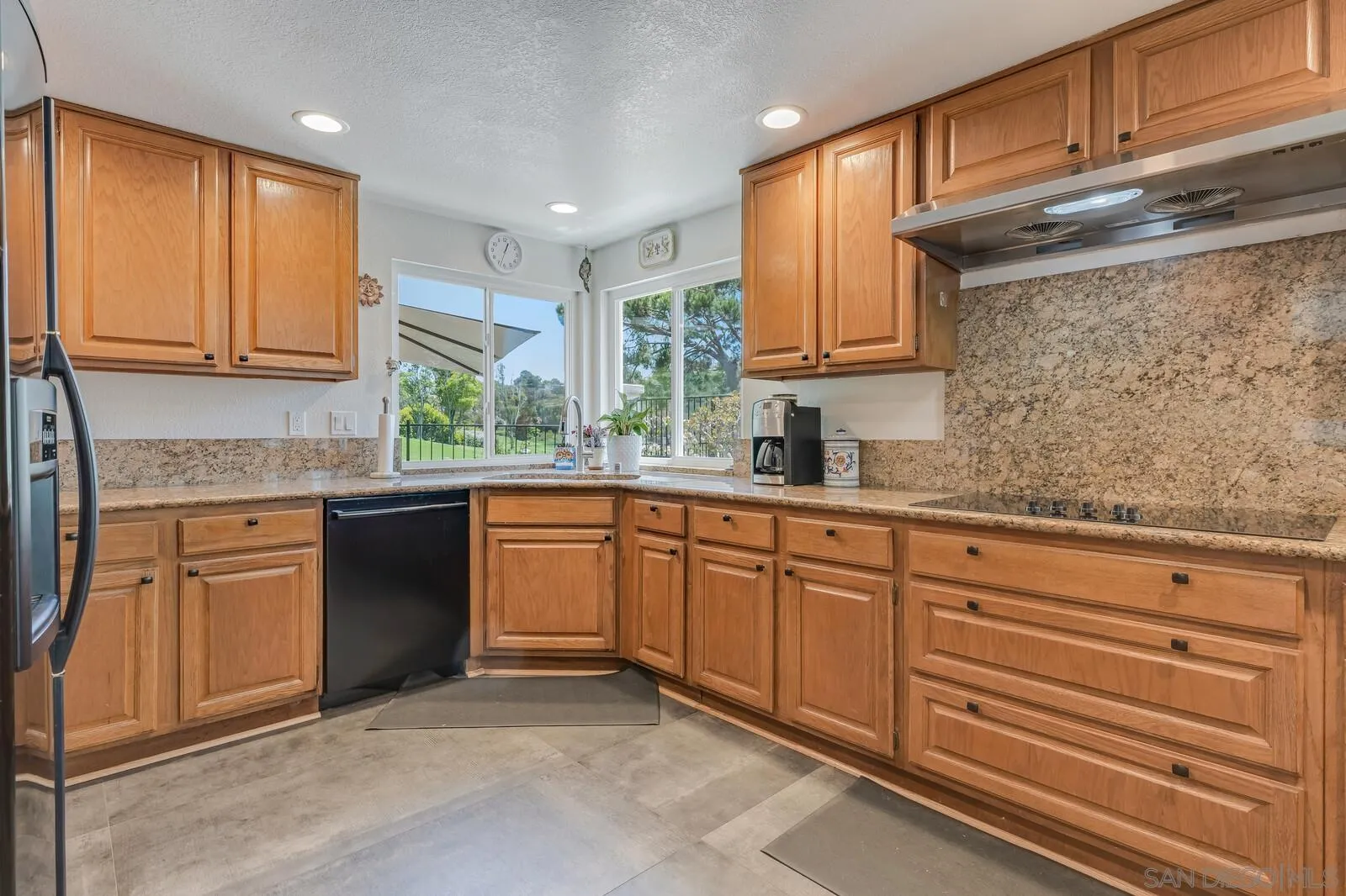 14921 Tercer Verde Del Mar, CA 92014 - Photo 12 of 37 a kitchen with granite countertop wooden cabinets stainless steel appliances a sink and a window