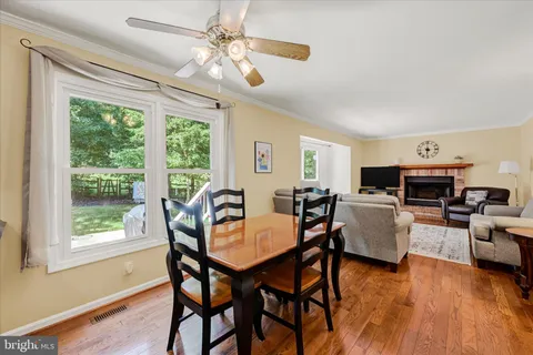 a kitchen with stainless steel appliances granite countertop a dining table chairs refrigerator and microwave