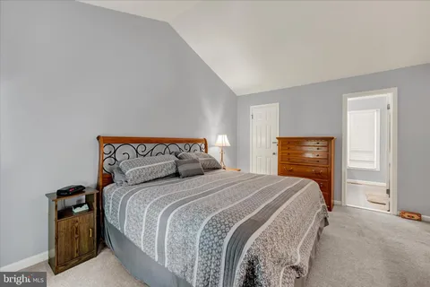 a bedroom with a bed and large windows