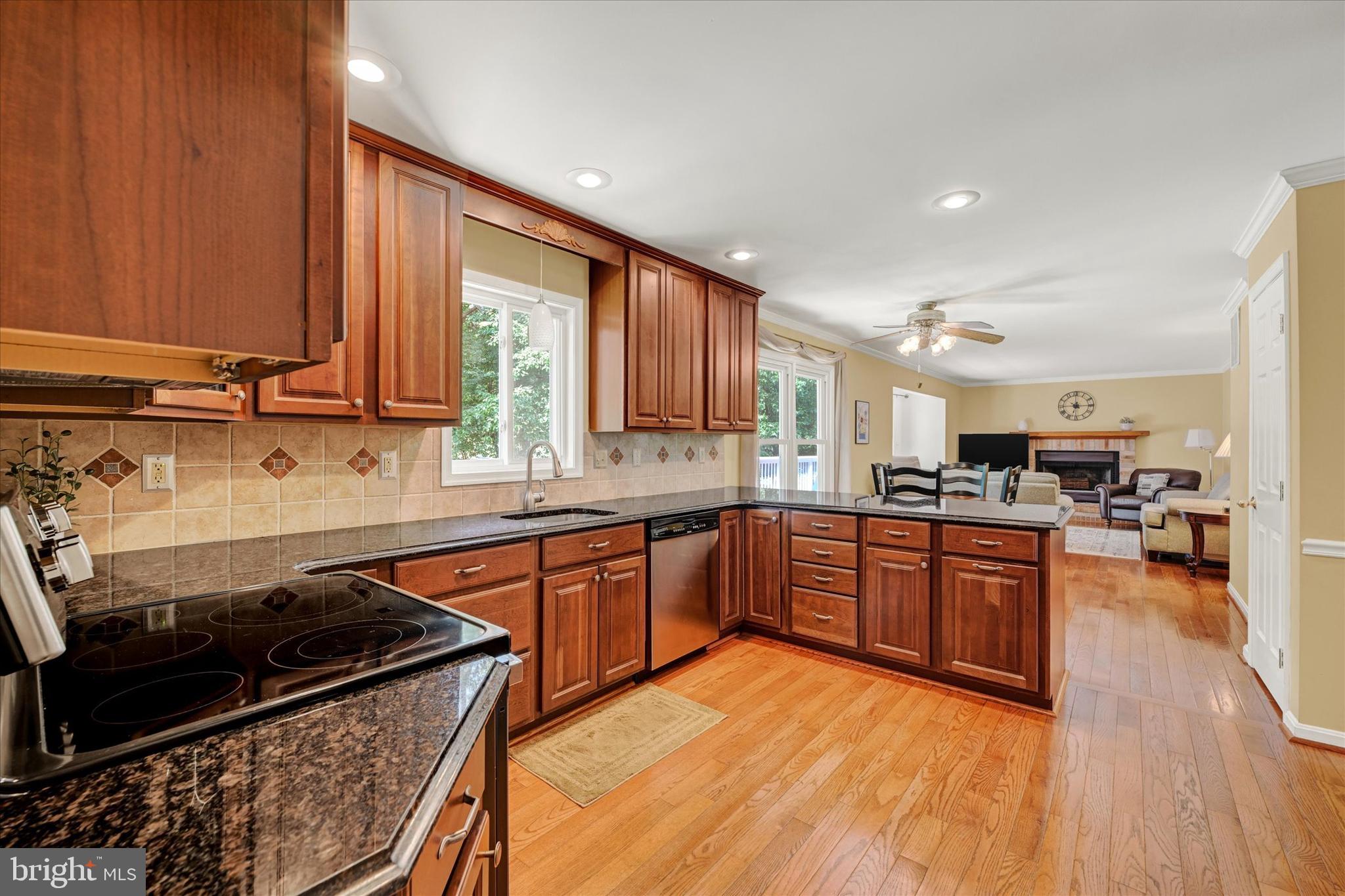 9006 Naygall Road Baltimore, MD 21234 - Photo 10 of 34 a kitchen with stainless steel appliances granite countertop wooden cabinets a sink dishwasher a stove and a refrigerator with wooden floor