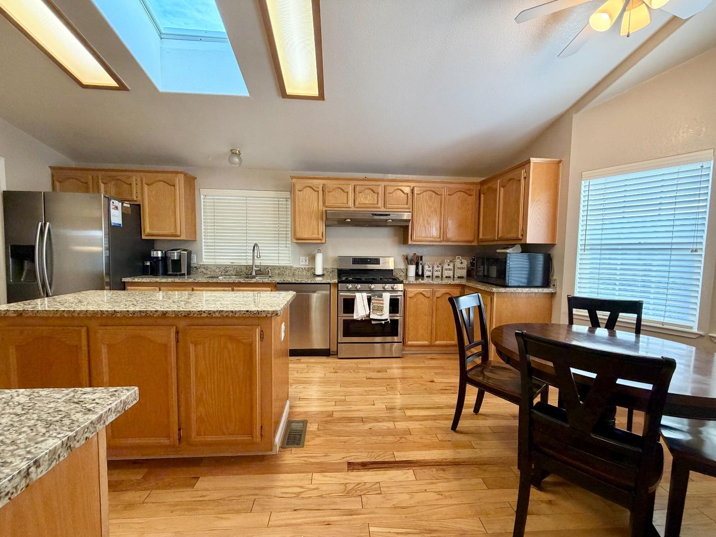 120 Dixon Landing Road, Unit 147 Milpitas, CA 95035 - Photo 9 of 21 a kitchen with stainless steel appliances granite countertop a stove top oven a sink a dining table and chairs