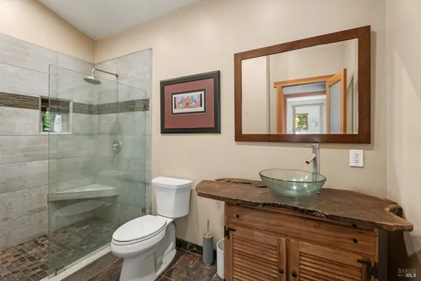 a bathroom with a granite countertop toilet sink and mirror