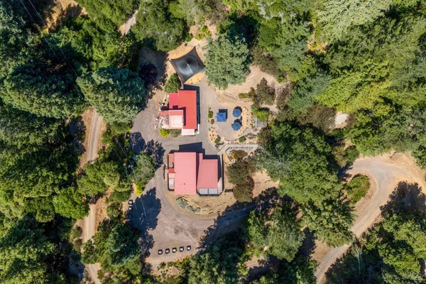 an aerial view of residential house with outdoor space and trees all around