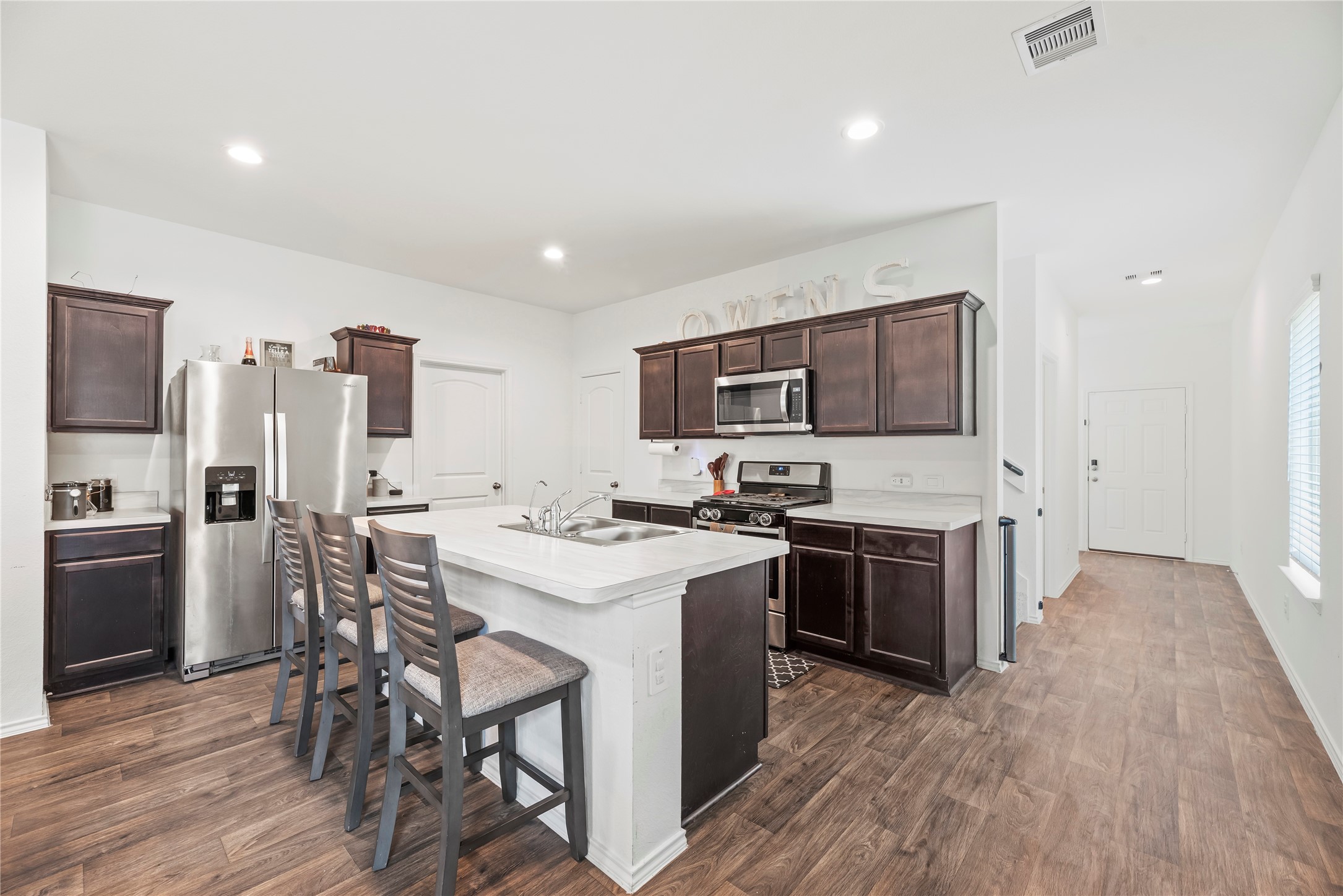 22603 Aspen Tarn Trail Spring, TX 77373 - Photo 6 of 21 a kitchen with a sink a stove a refrigerator cabinets and wooden floor