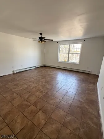 an empty room with windows and ceiling fan