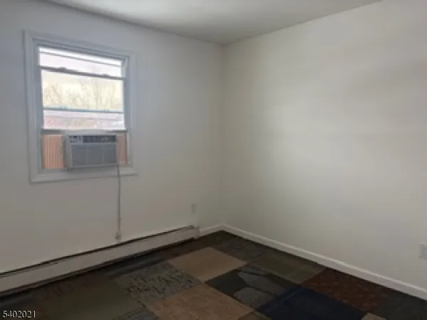 an empty room with wooden floor and window