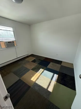 a view of staircase with white walls and a rug