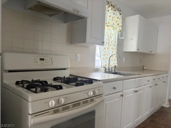 a large white kitchen with cabinets