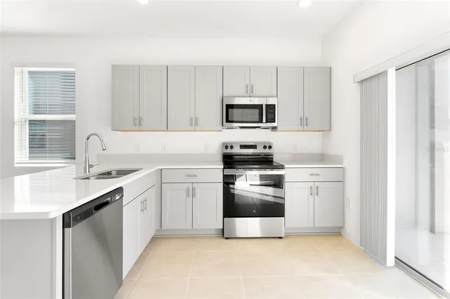 a kitchen with a stove a sink and a microwave