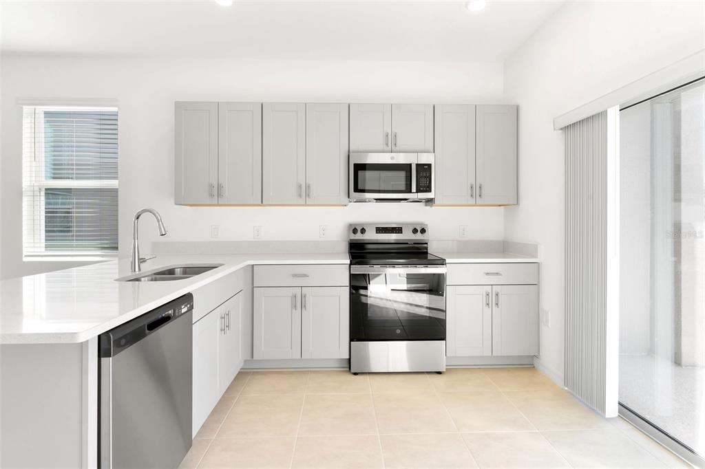 2987 Skyline Loop Kissimmee, FL 34758 - Photo 11 of 48 a kitchen with stainless steel appliances a sink cabinets and a window