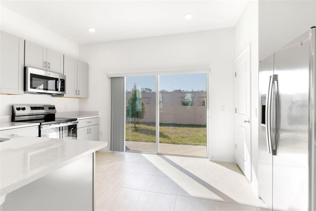 2987 Skyline Loop Kissimmee, FL 34758 - Photo 14 of 48 a kitchen with stainless steel appliances a refrigerator and a stove top oven