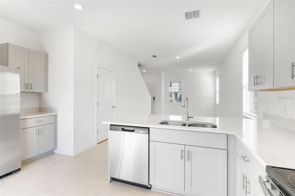 2987 Skyline Loop Kissimmee, FL 34758 - Photo 16 of 48 a kitchen with kitchen island white cabinets appliances and sink