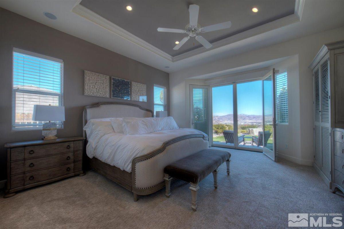 544 Echo Ridge Court Reno, NV 89511 - Photo 13 of 39 a spacious bedroom with a bed and a dresser next to a window