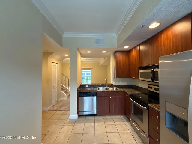 a kitchen with stainless steel appliances granite countertop a stove a sink and a refrigerator