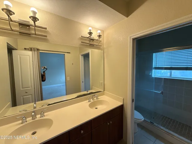 a bathroom with a sink double vanity granite and a mirror