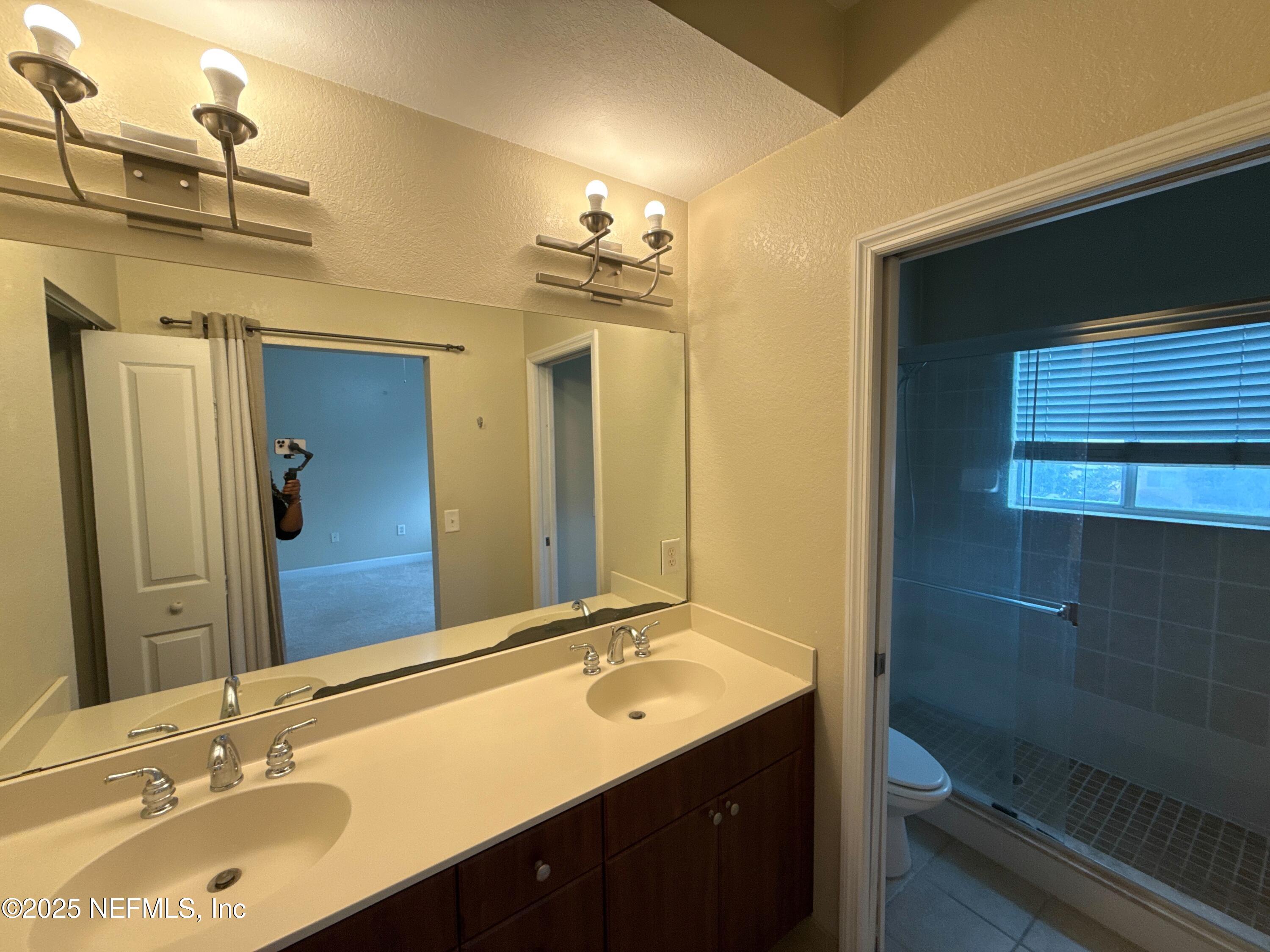 9745 Touchton Road, Unit 1725 Jacksonville, FL 32246 - Photo 9 of 20 a bathroom with a sink double vanity granite and a mirror