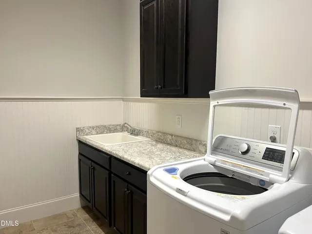 a bathroom with a granite countertop sink and a toilet