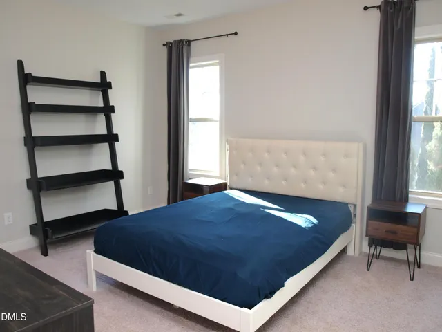 a bed sitting in a bedroom next to a window