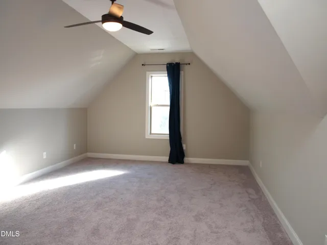 an empty room with a window and a ceiling fan