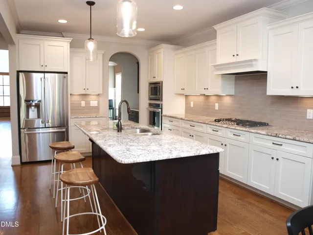 a kitchen with granite countertop a sink stainless steel appliances and cabinets