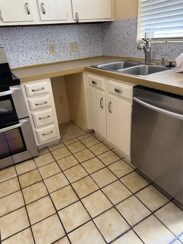 a kitchen with a sink a stove and cabinets