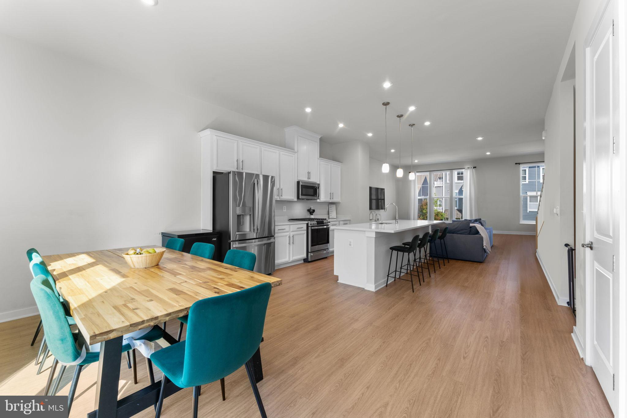 1783 Hickory Woods Road Dumfries, VA 22026 - Photo 10 of 54 a living room with furniture and a dining table with kitchen view