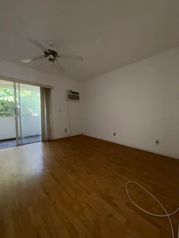 an empty room with windows and ceiling fan