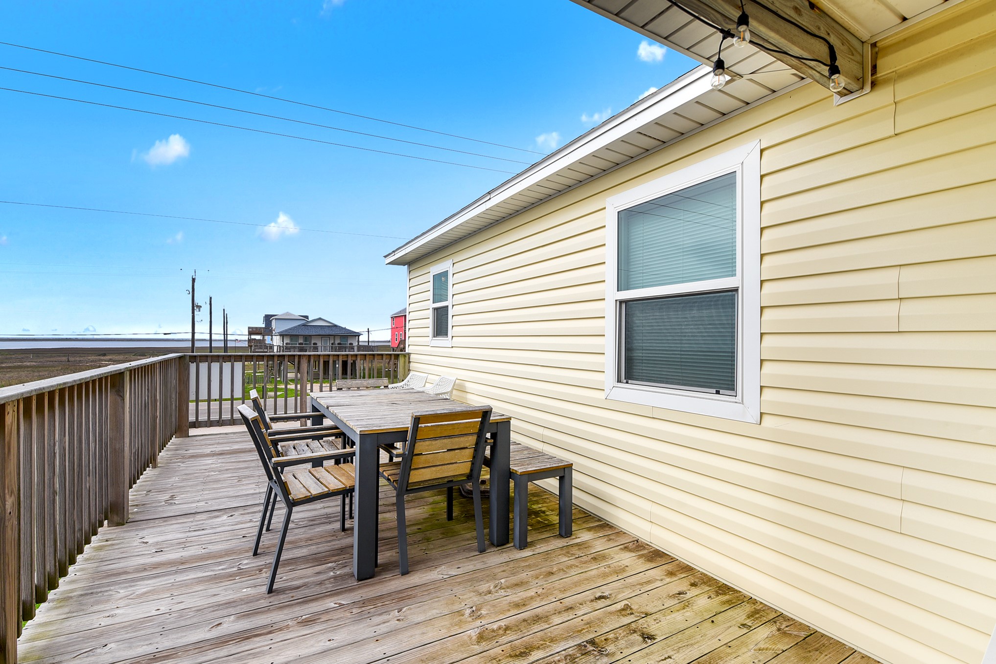 126 Nesmith Place Surfside Beach, TX 77541 - Photo 17 of 49 a view of a roof deck with table and chairs with wooden floor and fence