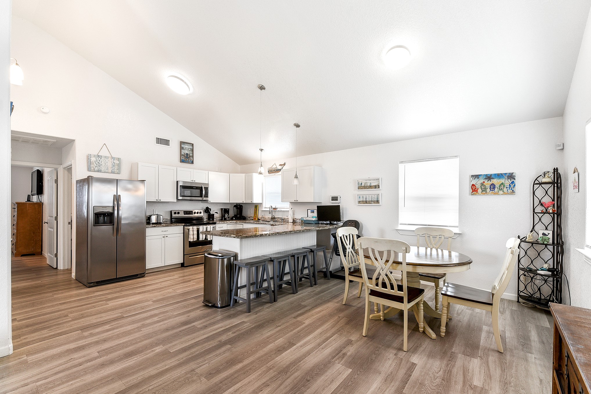 126 Nesmith Place Surfside Beach, TX 77541 - Photo 24 of 49 a kitchen with stainless steel appliances a dining table chairs stove refrigerator and cabinets