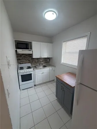a kitchen with a stove a sink and a refrigerator