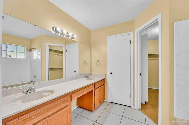 a spacious bathroom with a granite countertop sink and a mirror