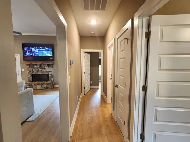 a view of a hallway with wooden floor and a living room