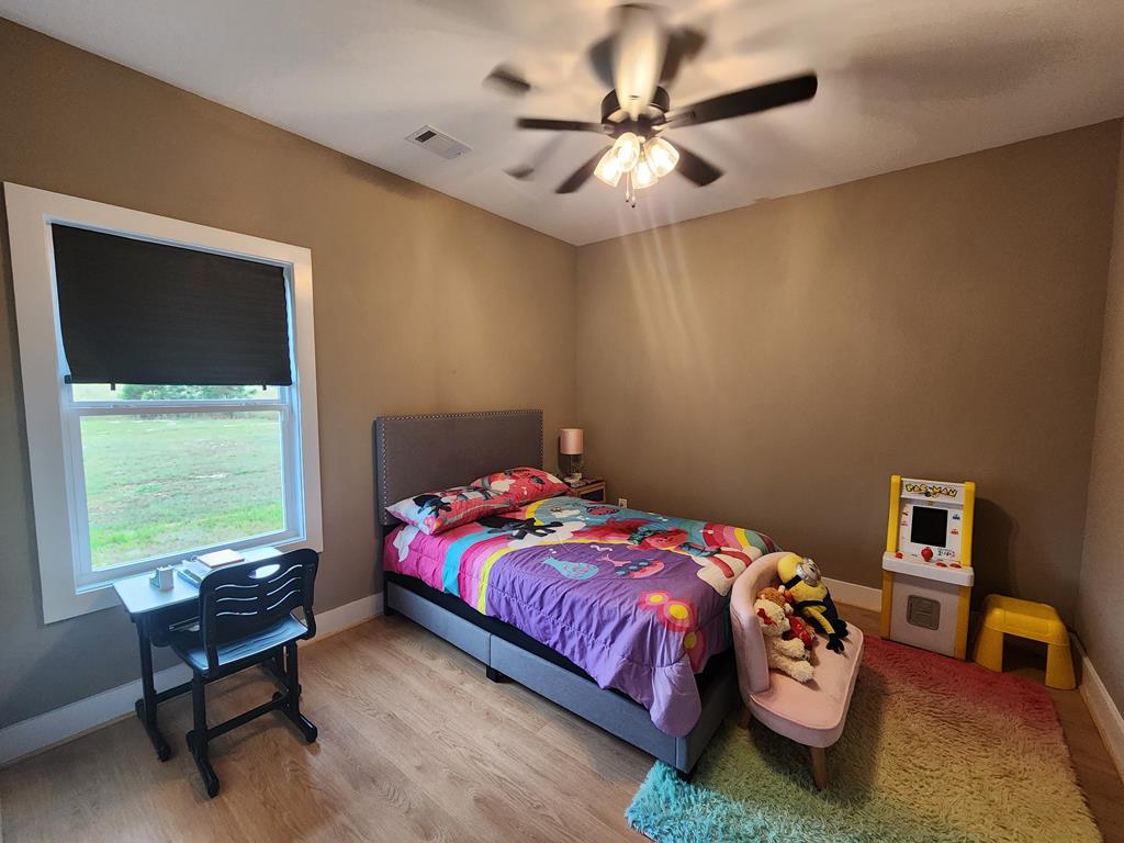 152 McLendon Road Fort Mitchell, AL 36856 - Photo 24 of 27 a bedroom with a bed and a chandelier