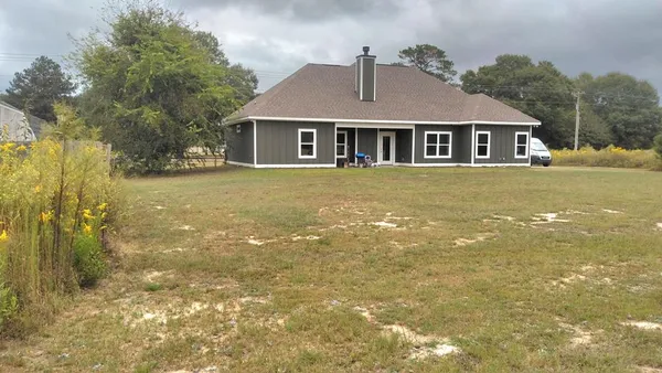 a front view of a house with a garden