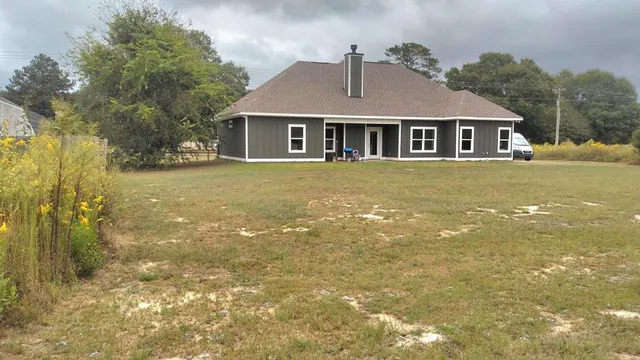 a front view of a house with a garden