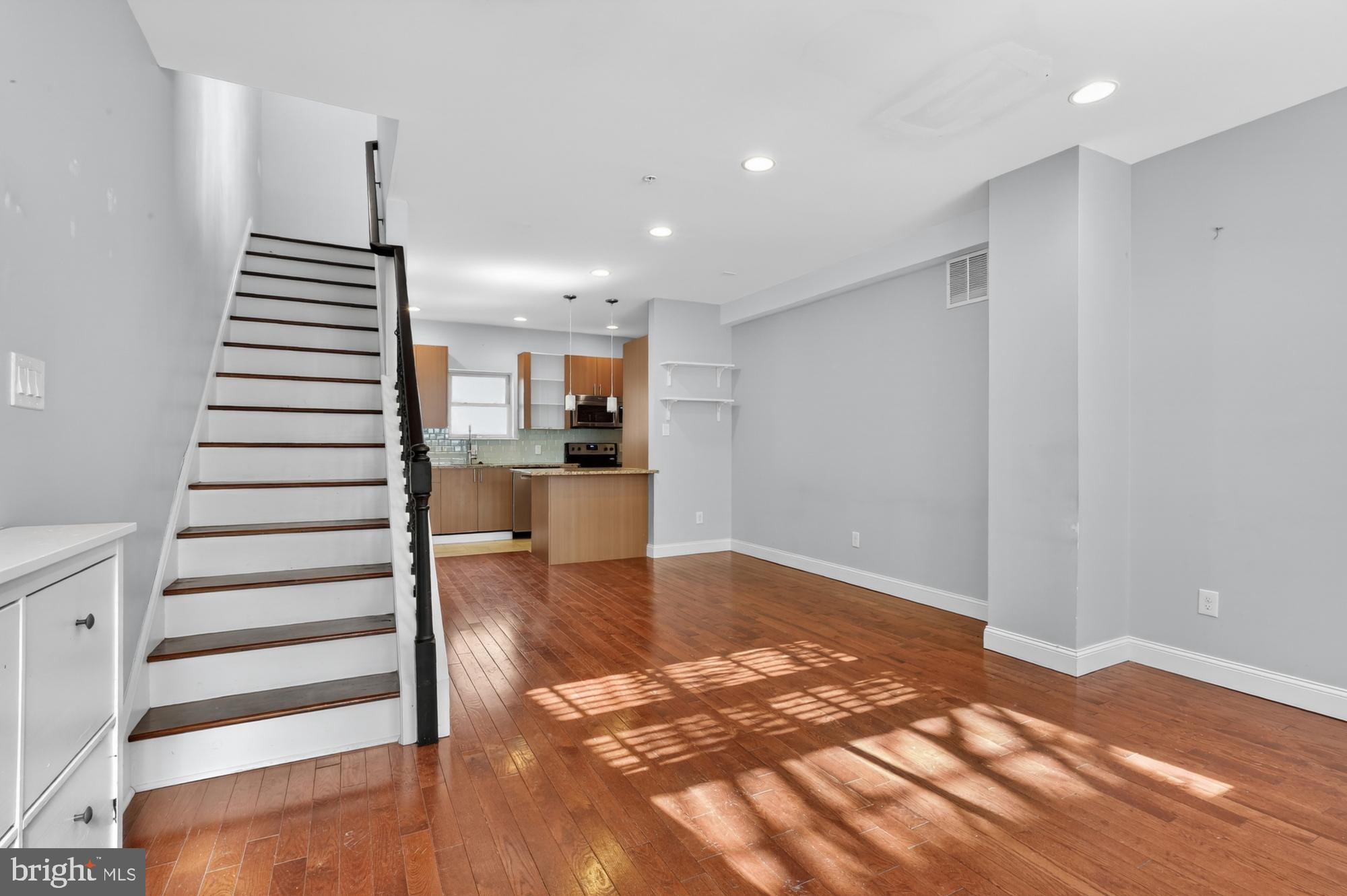 a view of a kitchen with wooden floor and a sink
