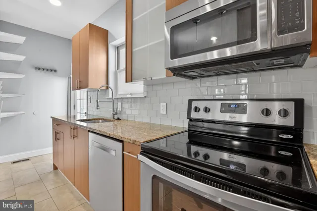 a kitchen with stainless steel appliances granite countertop a stove and a microwave