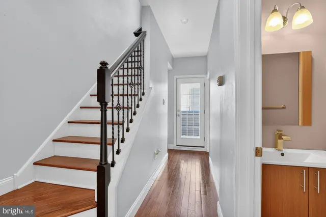 a view of a hallway with wooden floor and entryway