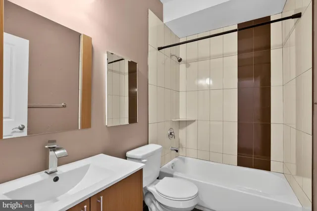 a bathroom with a bathtub shower sink mirror and toilet