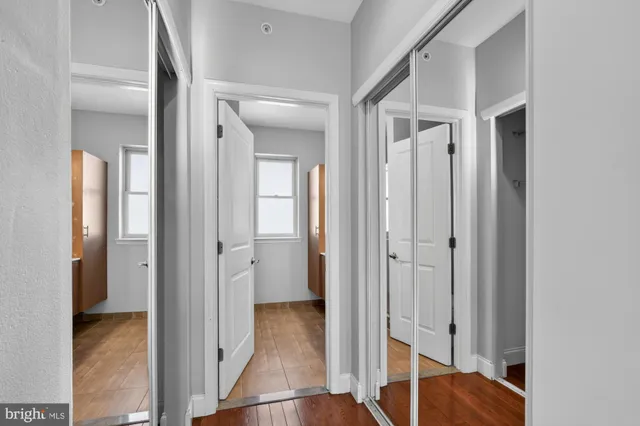 a view of a hallway with closet and wooden floor