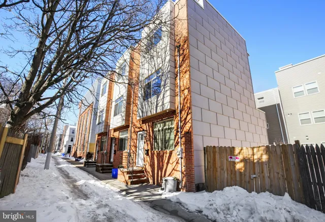 a backyard of a house with large trees and covered with wooden fence