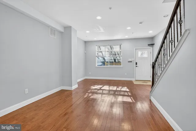 a view of empty room with wooden floor