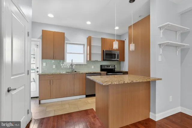 a kitchen with stainless steel appliances granite countertop a stove a sink and a refrigerator