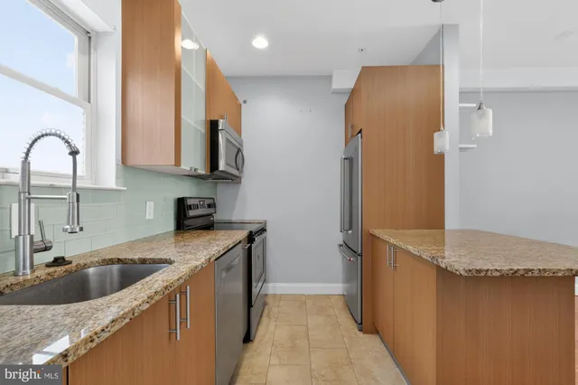 a kitchen with stainless steel appliances granite countertop a sink stove and refrigerator