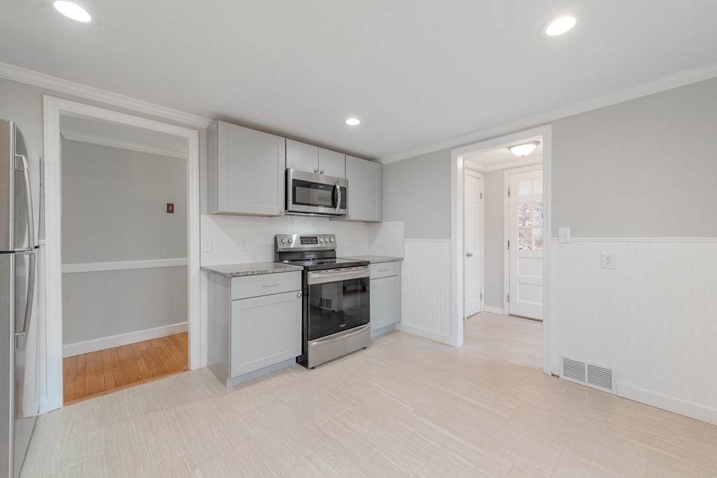 438 Tinkham Road Springfield, MA 01129 - Photo 2 of 23 a kitchen with white cabinets and stainless steel appliances