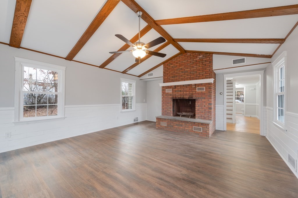 438 Tinkham Road Springfield, MA 01129 - Photo 8 of 23 an empty room with wooden floor fireplace and windows