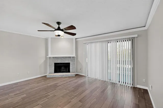 wooden floor fireplace and windows in an empty room