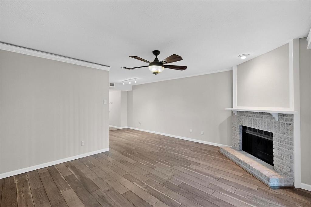 5840 Spring Valley Road, Unit 810 Dallas, TX 75254 - Photo 12 of 40 wooden floor in an empty room with a fireplace